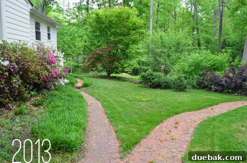 Outdoor Living Reimagined 7 After: Beautifully manicured backyard with revealed brick walkways and open grass areas.