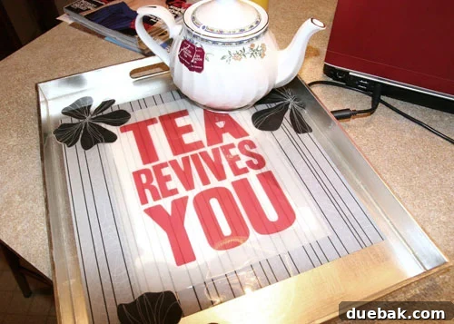 The completed DIY tea tray with a high-gloss resin finish and the 'Tea Revives You' slogan prominently displayed, ready for use.