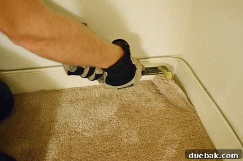 removing carpet with crowbar in corner