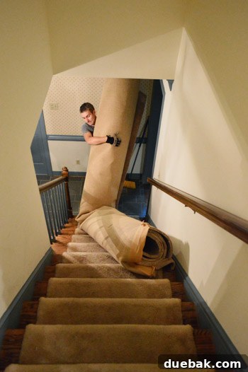 hauling old carpet roll down stairs