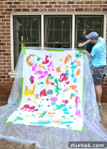 The painted fabric backdrop taped to the side of a house for the photo shoot.
