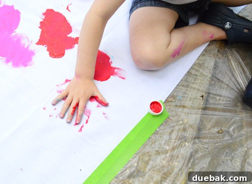 Clara's handprint and footprints on the colorful fabric backdrop.