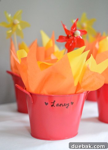 Dragon's Lair Birthday Bash 14 A dragon birthday party favor bucket filled with fiery yellow and orange tissue paper, ready to hold treats.