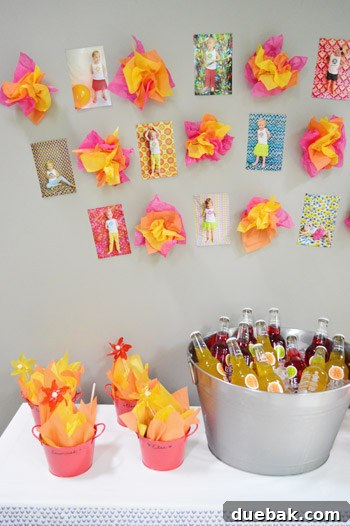 Dragon's Lair Birthday Bash 16 A display of Clara's monthly growth photos taped to a wall, interspersed with fire-themed tissue paper decor at her dragon party.