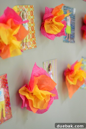Dragon's Lair Birthday Bash 17 Close-up of vibrant tissue paper fire puffs decorating a wall among framed photos at a birthday party.