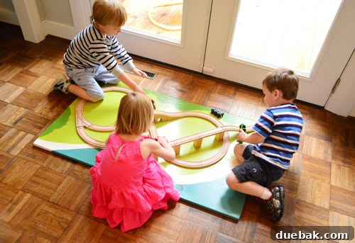 Dragon's Lair Birthday Bash 19 Kids playing with a DIY wooden train board at a birthday party, an engaging activity for young guests.