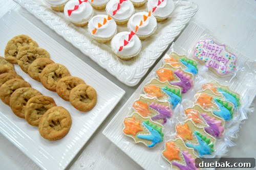 Dragon's Lair Birthday Bash 21 A delightful dessert table at a dragon birthday party, featuring custom cookies, cupcakes with dragon scales, and footprint cookies.