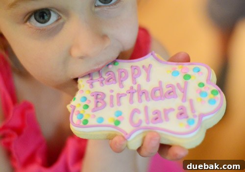 Dragon's Lair Birthday Bash 23 A heartwarming candid photo of a young girl happily eating a special birthday cookie.