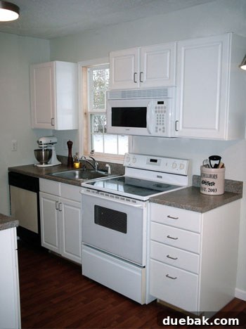 Close-up of new white kitchen cabinets and wood laminate flooring