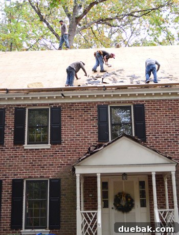 Major Home Upgrades: Furnace and Roof 3 Roofing contractors beginning the removal of old shingles from the house.