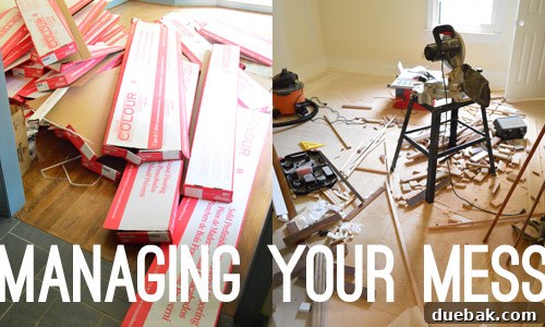 A collection of sawdust, wood scraps, and empty cardboard boxes from hardwood flooring, indicating the mess generated during installation.