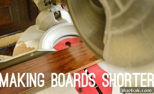 A miter saw being used to cut a hardwood floor plank shorter, demonstrating a common task during installation.