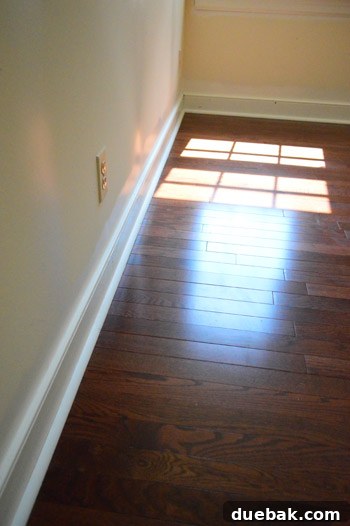 A close-up of a hardwood floor plank being cut with a miter saw, highlighting the precision needed for end pieces.
