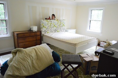 Third Home, First Footprint 13 Our master bedroom on Day One, showing the headboard being reassembled, with a person using a power drill