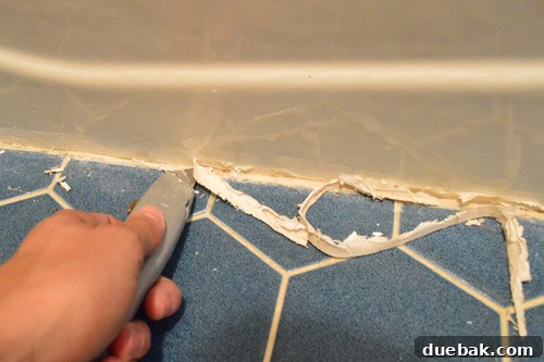 Ditch Your Outdated Sliding Shower Door 14 Using a box cutter to remove caulk from tub base