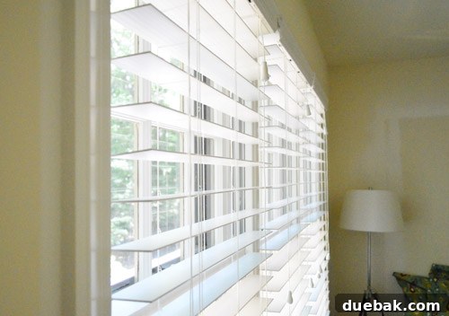Effortlessly Install White Faux Wood Window Blinds 5 Detailed view of a hand screwing a blind mounting bracket into a window frame