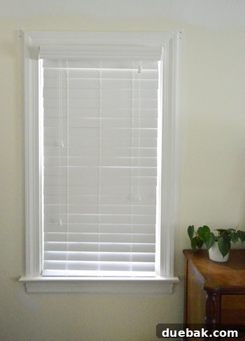 Effortlessly Install White Faux Wood Window Blinds 10 Newly installed faux wood blinds in a living room, providing privacy and light control
