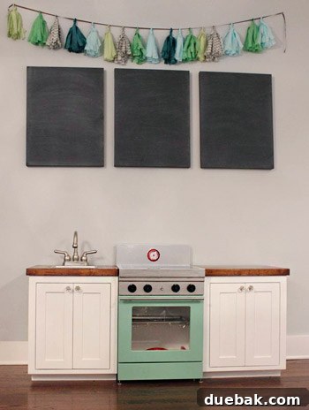 Zoey's custom play kitchen with detailed cabinetry and stove, built from scrap materials