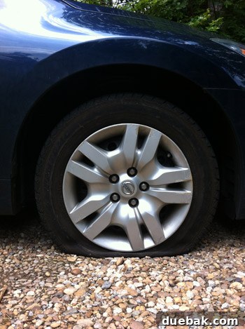 Close-up of a flattened car tire, victim of a stray screw during home renovation