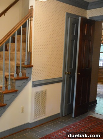 Before shot of the foyer with old wallpaper