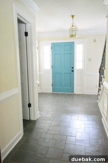 The Bold Secret Behind Your Front Door 6 After painting: vibrant teal door with existing yellow walls and brass fixture