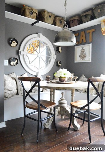 Townhouse Takeover: Unleashing Cozy Creativity 13 Kitchen featuring dark wood counters, painted cabinets, a built-in banquette with a large mirror, and elegant lighting.