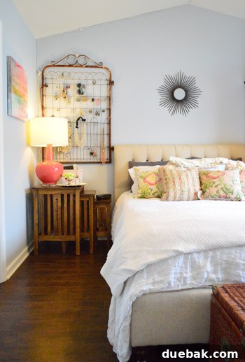 Townhouse Takeover: Unleashing Cozy Creativity 16 Master bedroom with a lofted ceiling, fluffy white bedding, elegant tufted headboard, and vintage gate jewelry holder.