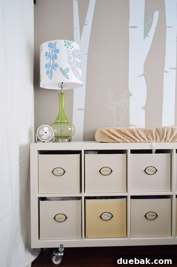 Townhouse Takeover: Unleashing Cozy Creativity 18 Charming nursery featuring light furnishings, a sweet tree decal, and personalized chalk creatures peeking from trees.