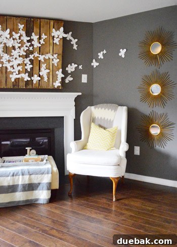 Townhouse Takeover: Unleashing Cozy Creativity 4 Stylish living room with dark walls, light furniture, and DIY gilded starburst mirrors.