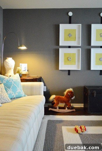 Townhouse Takeover: Unleashing Cozy Creativity 9 Living room with dark walls, light furniture, and DIY architectural art frames with cheerful yellow squares.