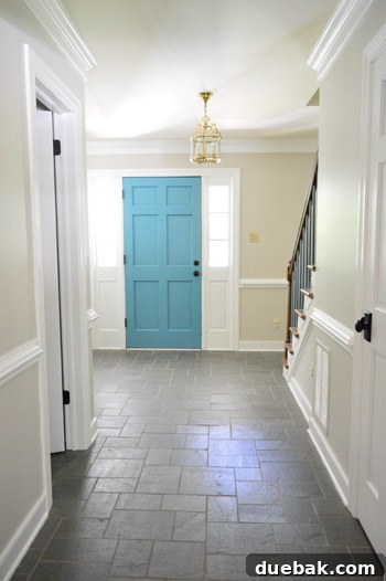 The foyer with old carpeted stairs and blue trim, before its elegant renovation