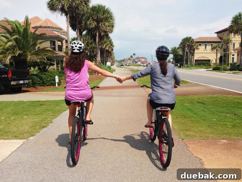 Two children riding bikes together, a cute moment from a family vacation in Destin