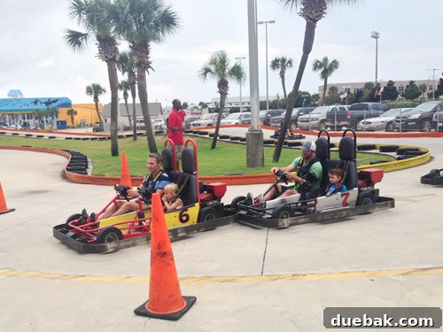 Children and adults enjoying go-kart racing on a track, a fun family activity
