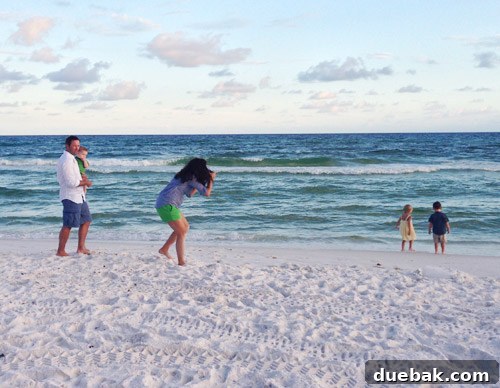 Family photographer capturing beach moments during sunset in Destin