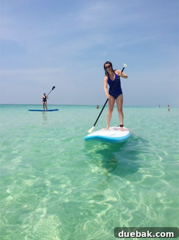 Kids enjoying a ride on a stand-up paddleboard with an adult in Destin, Florida
