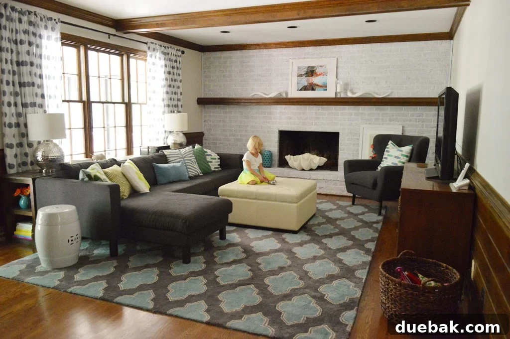 DIY Whitewashing: Transform Your Brick Fireplace 13 A stylish and colorful living room featuring navy blue furniture, graphic pillows and rug, rustic wood beams, and a newly whitewashed brick fireplace wall.