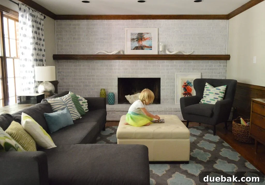 DIY Whitewashing: Transform Your Brick Fireplace 4 A modern living room featuring stylish navy blue furniture complemented by a newly whitewashed brick fireplace wall, adding brightness and texture to the space.