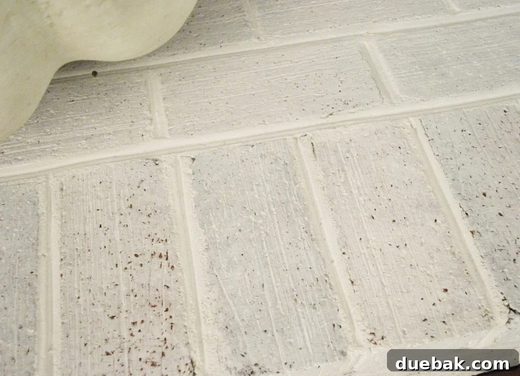 DIY Whitewashing: Transform Your Brick Fireplace 8 Detailed view of a whitewash brick hearth fireplace, highlighting the textured surface and subtle color variations achieved with the DIY technique.