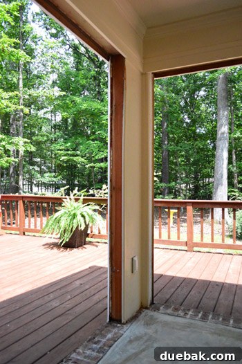 Close-up of exposed raw wood framing after door removal, showing unfinished edges