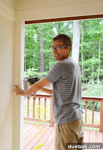 Installing PVC trim with a nail gun in sunroom opening, demonstrating secure fastening