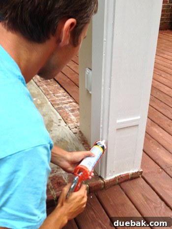 Applying caulk to seal gaps around new sunroom trim for weatherproofing