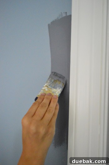 Side-by-side comparison of tinted primer and Benjamin Moore Black Pepper paint on a bedroom wall