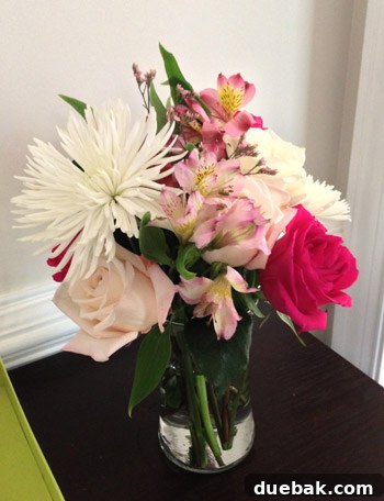 A vibrant mixed floral bouquet in a classic glass vase, showcasing a variety of colors and textures.