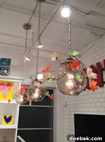 Seaside's Simple Pleasures: Window Shopping The Art of Simple 11 Customizable pendant lights with delicate floral details, showcasing a unique blend of craftsmanship and personalized design.