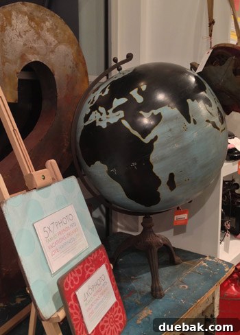 Seaside's Simple Pleasures: Window Shopping The Art of Simple 8 A custom-painted globe with blue, black, and gold details, showcasing a distressed finish for a unique decorative piece.