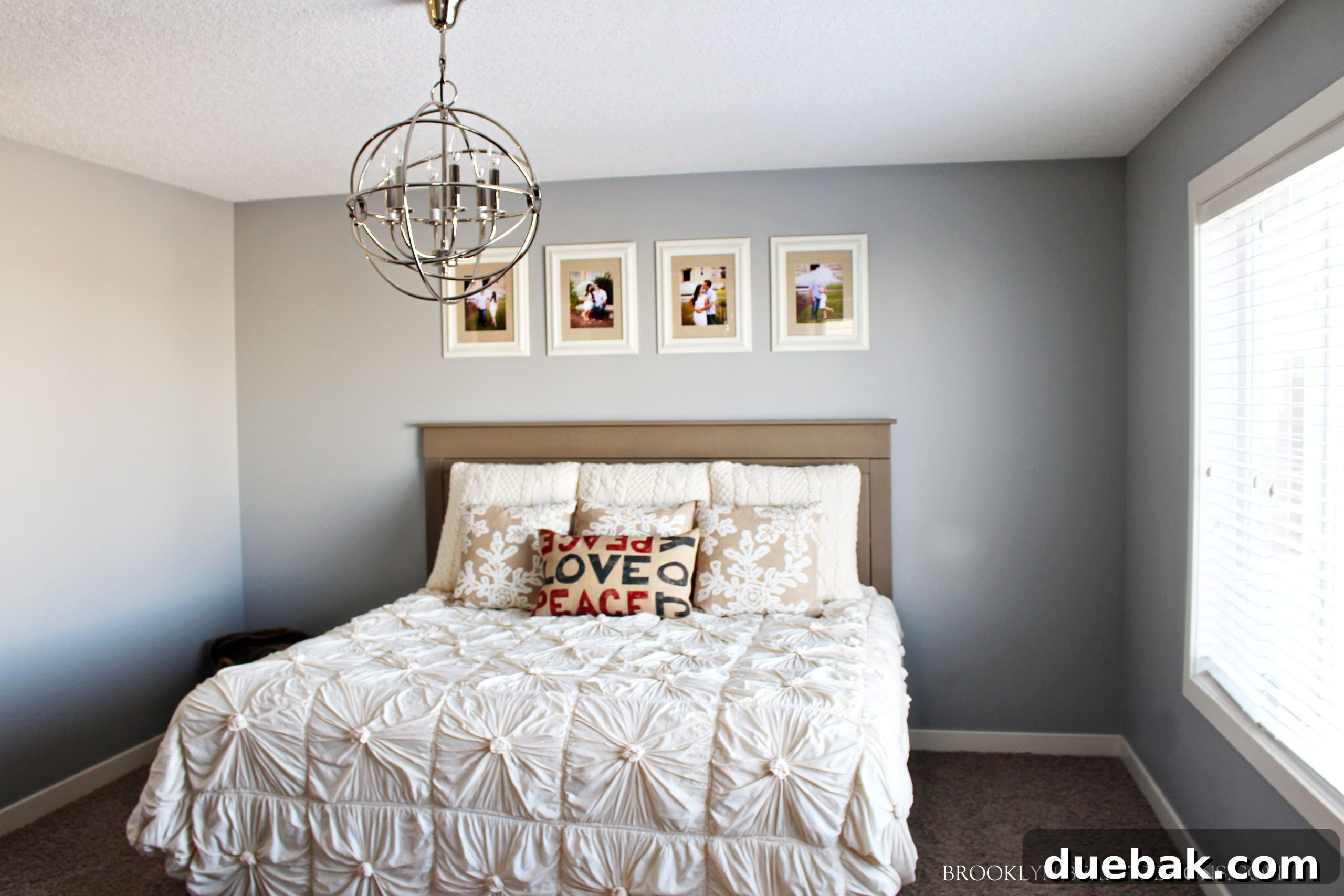 Elegant master bedroom with a distinctive light fixture, plush bedding, and serene decor, offering a peaceful retreat.
