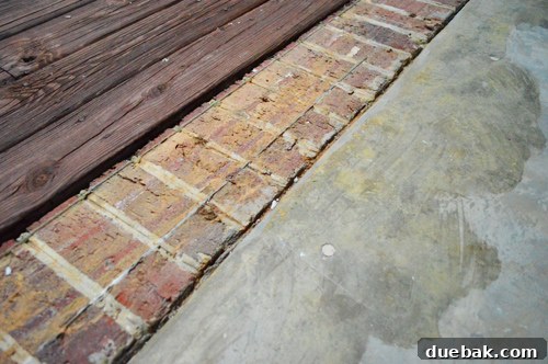 Beton Zemin İçin Boya mı Fayans mı? 7 Sunroom concrete floor with visible glue stains from previous carpet, highlighting imperfections