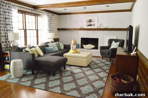 Renovated living room with newly painted walls and a whitewashed brick fireplace.