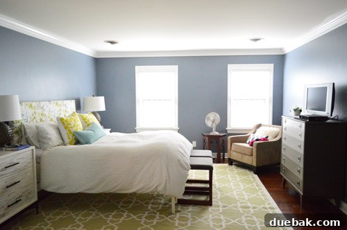 Renovated bedroom with new hardwood floors, painted walls, and updated trim, awaiting built-ins and window treatments.