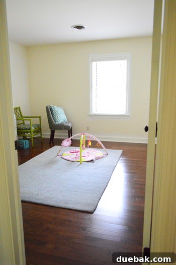 Spare room with new hardwood floors and painted trim, sparsely furnished, awaiting its future purpose.